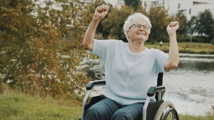 Elderly woman dancing in a wheelchair