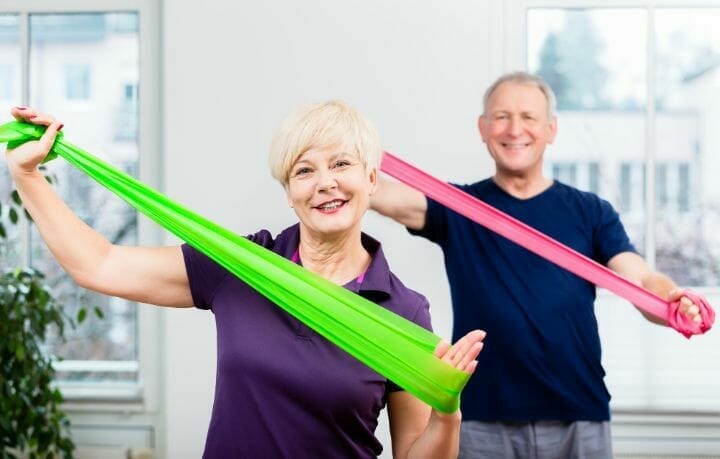 senior couple doing exercise with resistance band