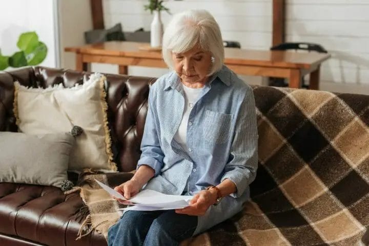 Elderly holding her bills to pay