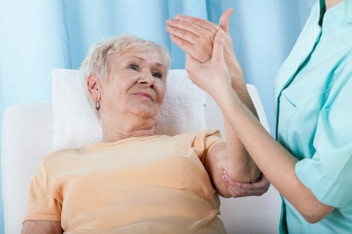 Nurse examining senior woman's arm