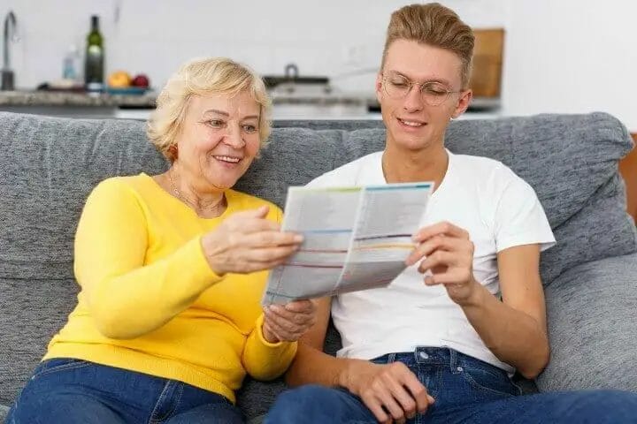 Senior woman and young grandson reading a brochure