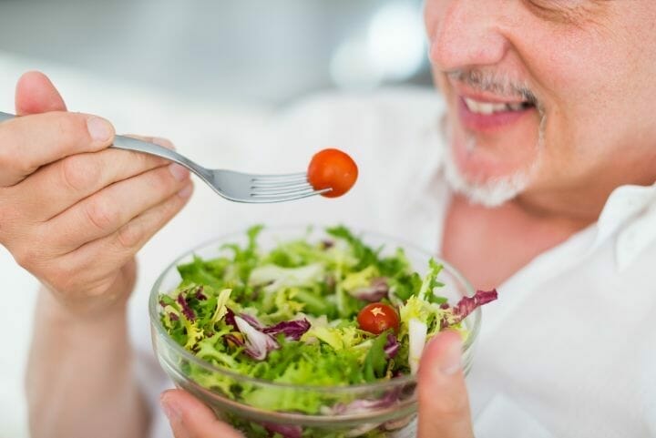 Middle aged man eating vegan salad