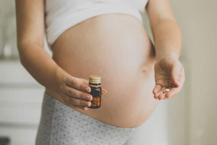 Pregnant Woman drinking her pills