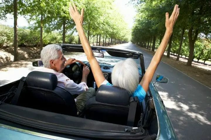 Senior couple enjoying ride in a sports car