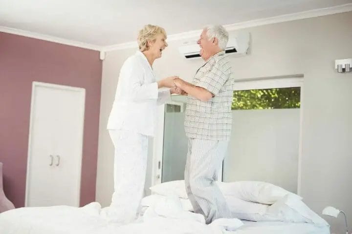 Senior couple jumping on the bed cheerfully