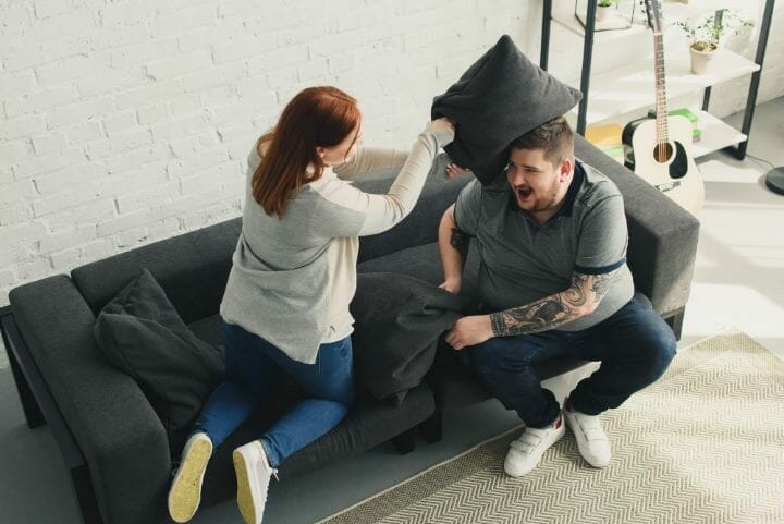 Overweight Couple having Pillow Fight