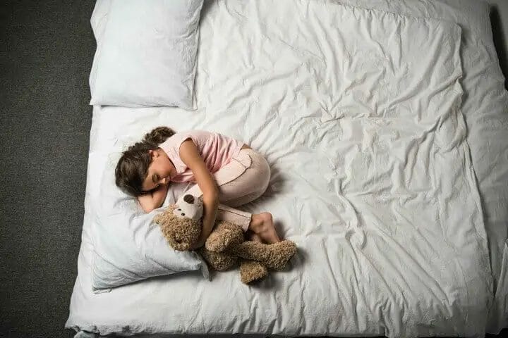 Little girl sleeping while hugging her stuff toy