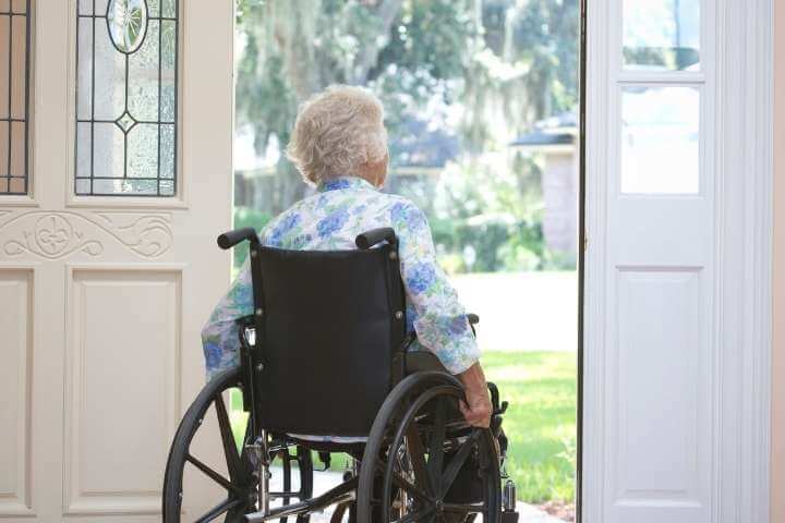 elderly woman on a wheelchair at the door