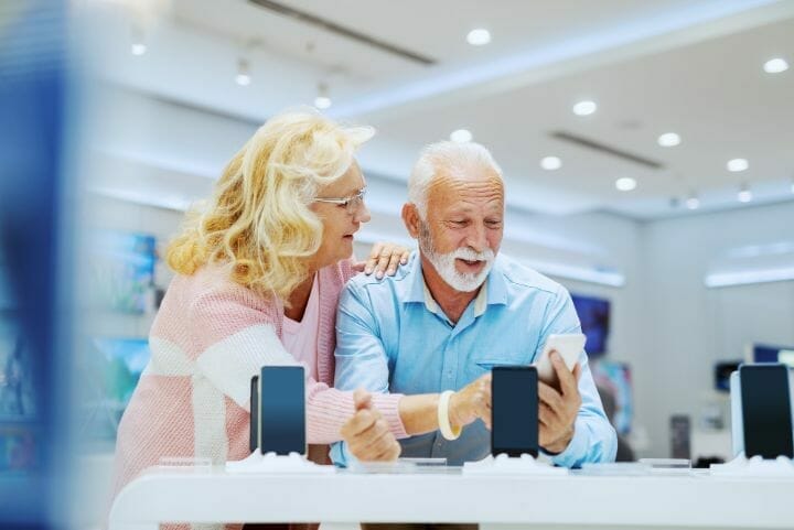 senior couple buying mobile phone