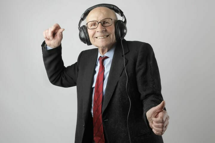 senior man with headphone listening happily
