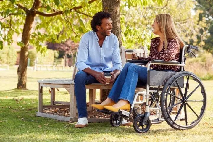 woman on a wheelchair having a date in a park