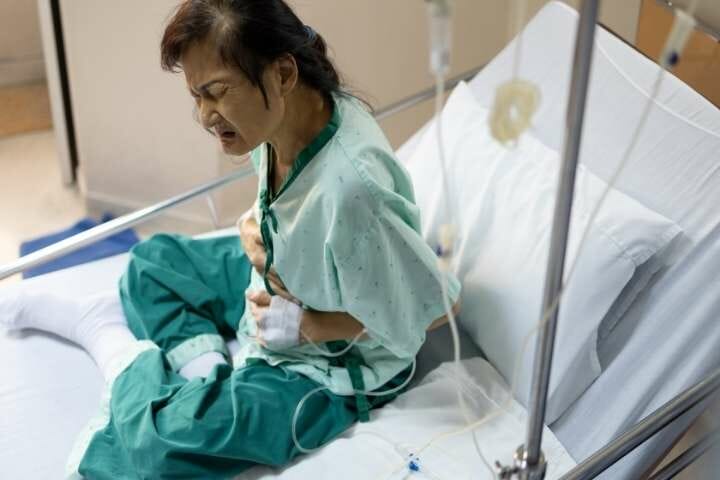 woman in hospital bed with stomach ache